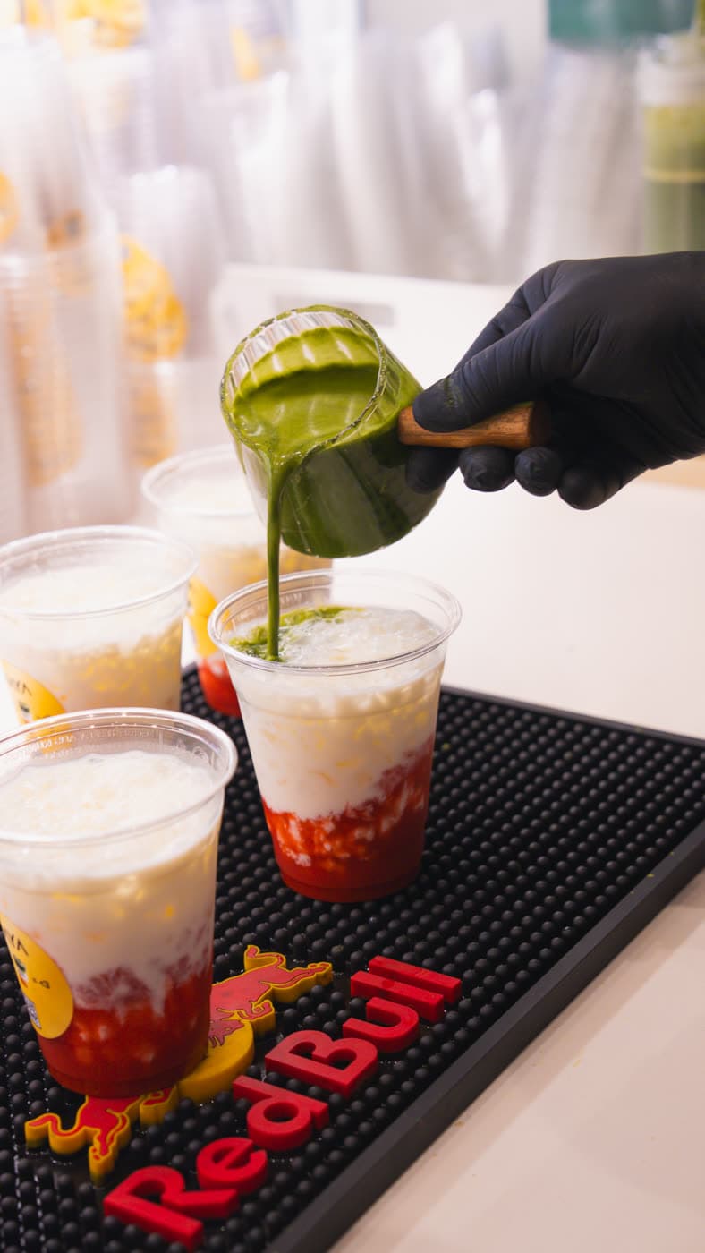 Matcha wird aus einem Krug in einen Becher gegossen